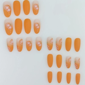 Long almond press-on nails with matte orange gradient and fresh orange slice patterns