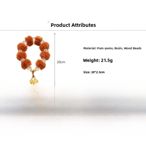 Détail du bracelet avec boules en peluche et perles en bois et pendentif fleuri