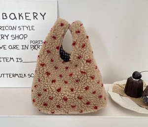 Détail du sac à main pelucheux beige à pois rouges avec doublure à carreaux