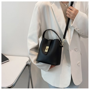 Black PU leather bucket bag with gold clasp shown on a model in a white blazer