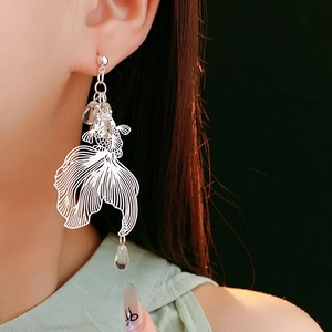 Detail of silver koi fish earrings with crystal teardrop drop on model for a refined look