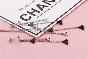Close-up of long tassel earrings with geometric triangle pendants and sparkling rhinestones