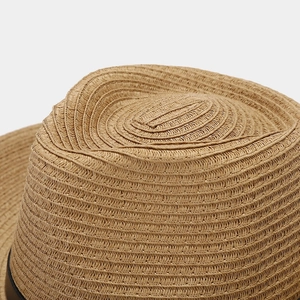 Macro shot of the spiral woven paper straw texture on a khaki sun hat crown