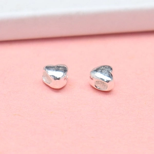 Polished S925 sterling silver heart beads for jewelry making on pink background