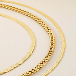 Detailed view of triple-layered golden stainless steel flat snake and cuban link chains
