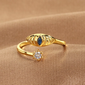 Adjustable golden evil eye ring with blue marquise stone and white zircon on silk fabric