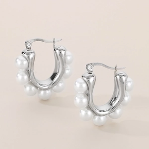 Macro view of silver U-shaped stainless steel earrings with white pearl inlay details