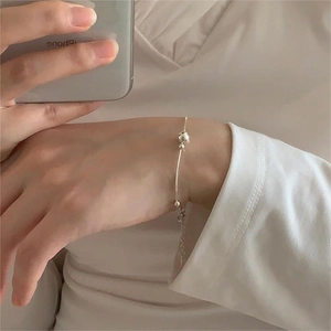 Macro shot of minimalist S925 sterling silver beaded bracelet with adjustable chain extension
