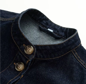 Détail du col montant sur veste en jean indigo foncé avec surpiqûres dorées