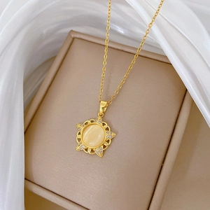 Gold starburst necklace with cat eye stone and diamonds on white silk display