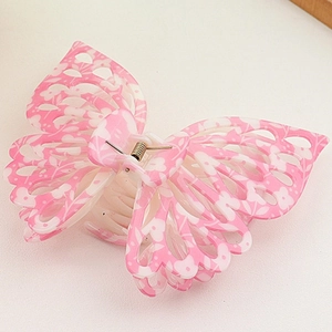 Macro detail of the floral butterfly hair claw clip with intricate hollow wing patterns
