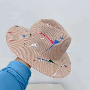 Close-up of khaki straw hat with colorful hand-painted graffiti ink splatters