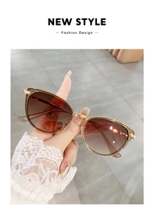 Close-up of golden metal frame cat eye sunglasses with brown gradient lenses and 942 model code
