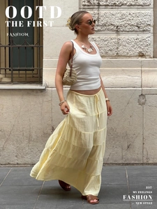 Detail of layered yellow tiered maxi skirt with natural textured fabric and ruffles