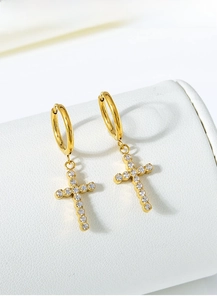 Detail of gold titanium steel hoop earrings with sparkling zircon cross pendants