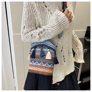 Una piccola borsa a tracolla in stile etnico ricamata con nappe colorate vivaci