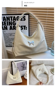 Detail of off-white hobo tote bag featuring a silver butterfly charm and chain detail