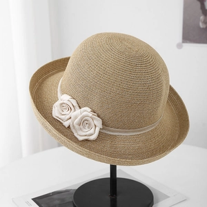 Gros plan détaillé d'un chapeau de paille orné de deux élégantes fleurs de rose en tissu