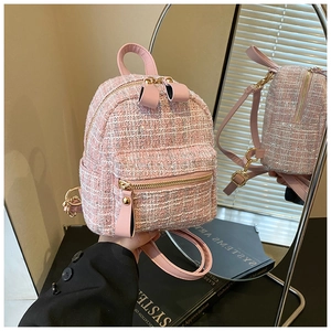 Close-up of pink tweed backpack featuring woven texture and premium leather straps
