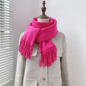 Close-up of rose pink cashmere-feel scarf with fringe on mannequin in soft daylight