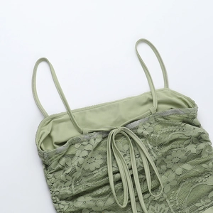 Detail of the green lace dress back showing adjustable lace-up ties and intricate floral mesh