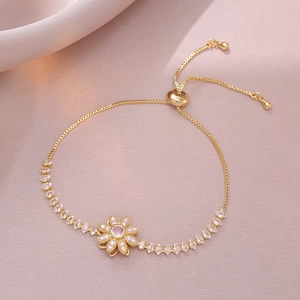 Dettaglio del bracciale regolabile dorato con gemma rosa e pietre di zircone marquise bianche