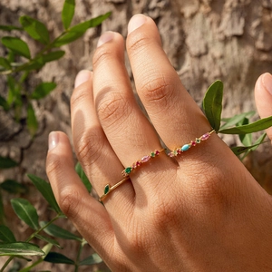 Close-up of stacked gold S925 silver rings with colorful marquise zircons in natural light