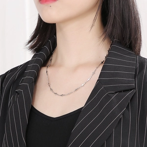Detail of silver stainless steel cross link chain necklace worn on a model's neck