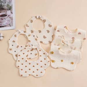 Detailed view of assorted soft cotton gauze baby bibs with bear and lemon prints