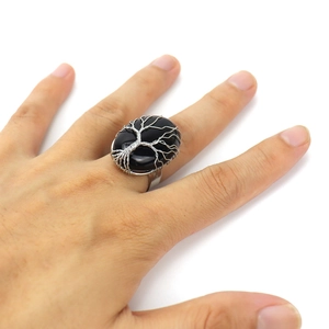 Macro shot of silver wire handmade tree of life wrap on oval black crystal ring