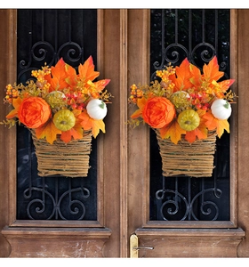 Autumn harvest basket decor with pumpkins and maple leaves hanging on dark wooden doors