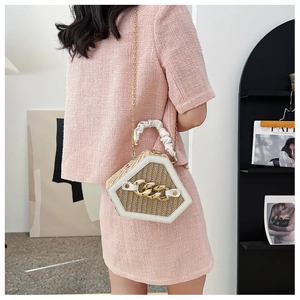 Detailed view of beige woven shell bag with gold chain and white leather handle