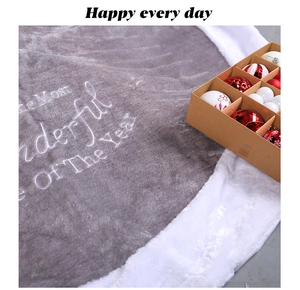 Detail of grey velvet Christmas tree skirt with white plush edge and seasonal embroidery