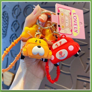 Detail of cute orange dog and red bear cartoon car keychains with silicone wristbands