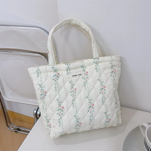 Detail of quilted floral handbag with pink roses and a 'Simple Wish' fabric label