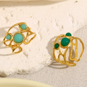 Detail of hollow wide gold-plated stainless steel rings with green cabochon stones