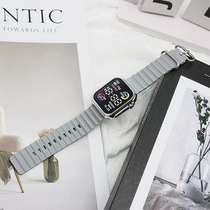 Macro detail of the grey silicone wave strap and silver metallic case of the LED digital watch