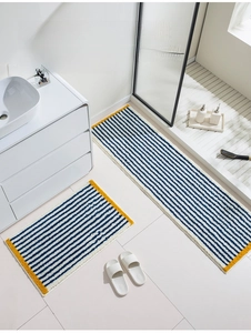 Detailed view of blue and white striped bath mats with soft velvet flocking texture