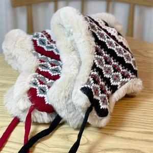 Close-up of jacquard knit winter hats with warm faux fur lining and ear flaps