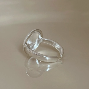 Macro shot of S925 sterling silver geometric earring showing hallmark detail and reflection