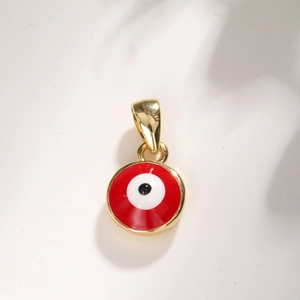 Macro detail of a round gold-plated red evil eye pendant with a polished finish