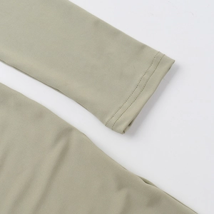 Nahaufnahme der Ärmel eines bohnen grünen Strickkleides mit feiner Doppelnaht und Textur