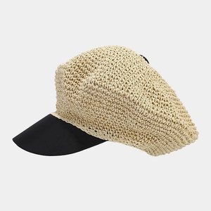 Detail of hand-woven straw baker boy hat with a contrasting black stiff brim for summer