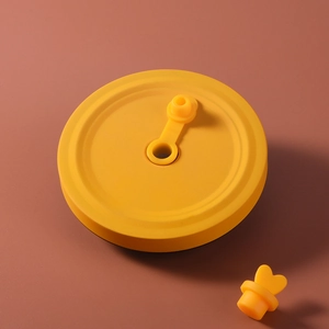 Yellow silicone tumbler lid with heart-shaped straw hole plug and matte finish