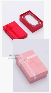 Close-up of red and pink jewelry gift boxes with ribbon bows and crystal bracelets