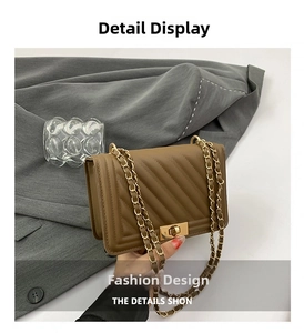 Detail of a brown quilted leather crossbody bag featuring a gold metal lock and chain strap