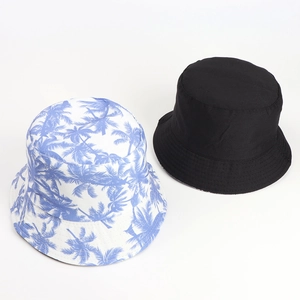 Dual-sided bucket hat detail featuring coconut tree print and solid black cotton fabric