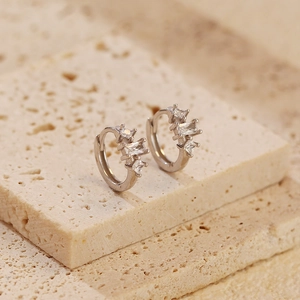Macro shot of silver S925 sterling silver hoop earrings with clear zircon stones on stones