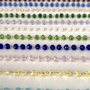 Detail of faceted crystal beads on gold chains in various colors for elegant necklaces