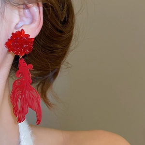 Detailed side view of a model wearing red resin flower and koi fish earrings